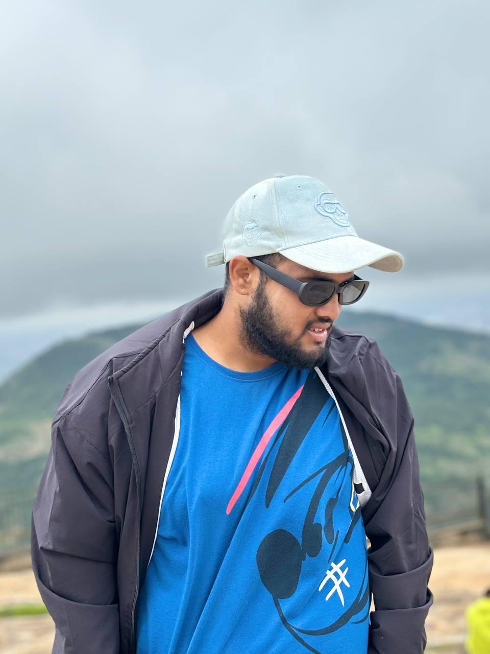 Dhanush P. Soorya outdoors, wearing a cap and jacket.